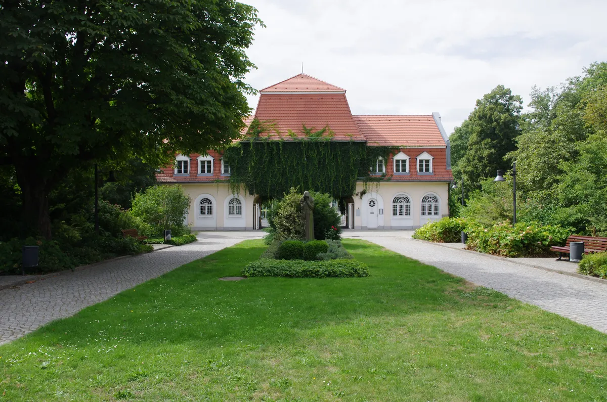 Eingangshaus des Friedhofs Baumschulenweg hinter einer begrünten Mittelanlage